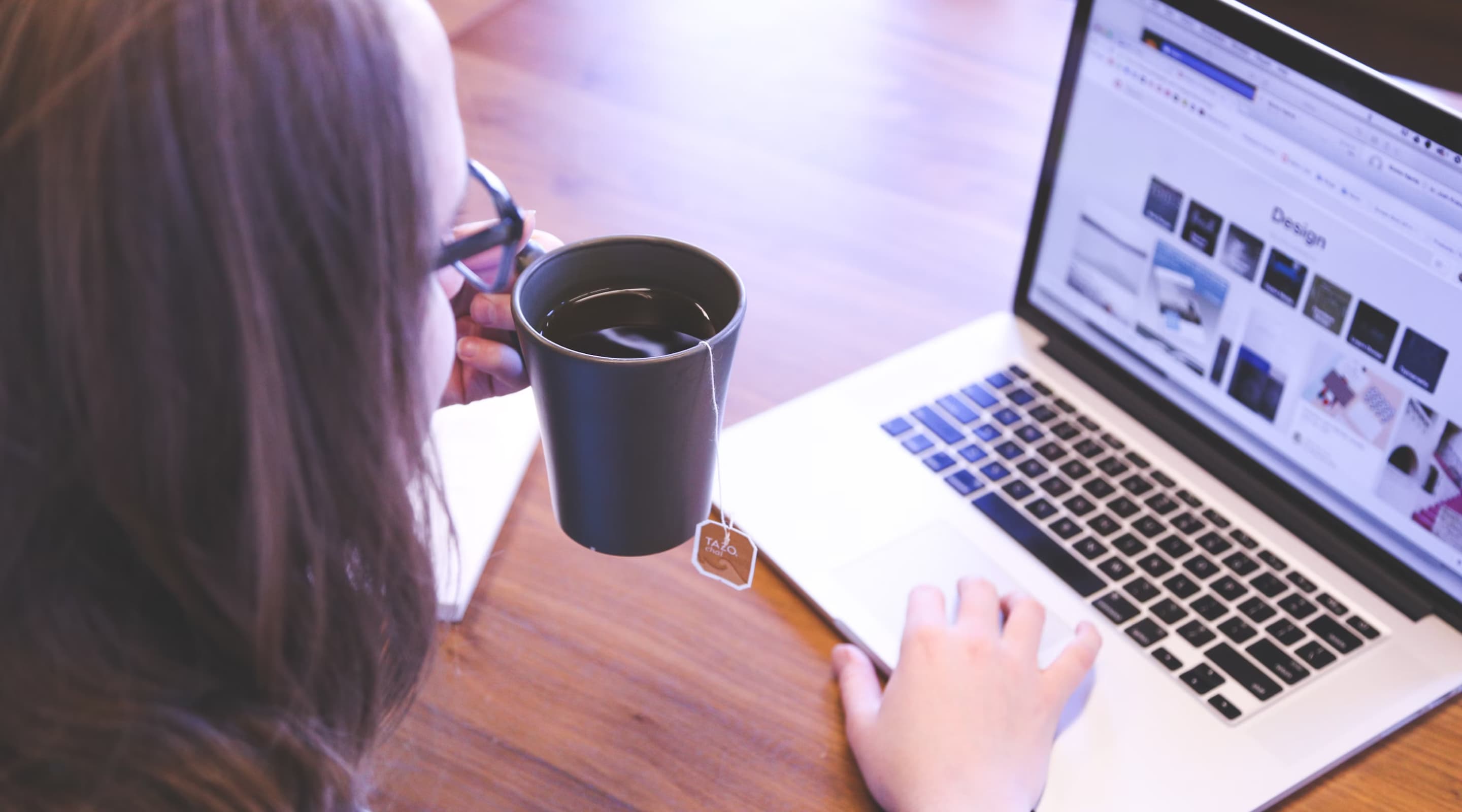 Bild Frau sitzt mit Kaffee an einem Laptop